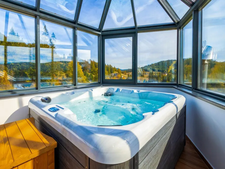 Jacuzzi sub cupola de sticlă, cu vedere spre pădurea de toamnă