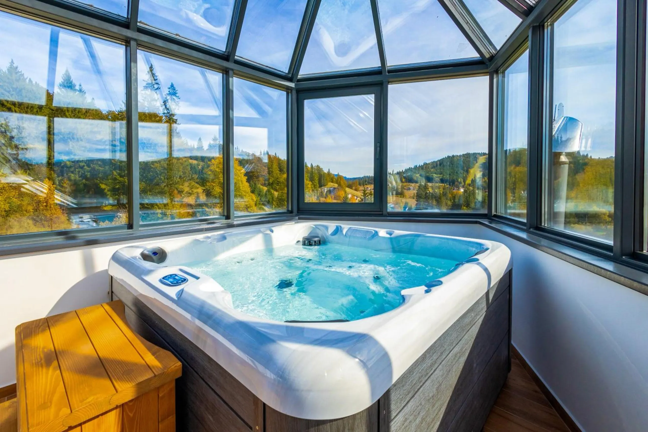 Jacuzzi-ul de sub cupola de sticlă a Vilei Szabó, cu pădurea de toamnă